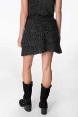 Minifalda tejida a crochet color ladrillo, con cintura alta y cordón trenzado con borlas.