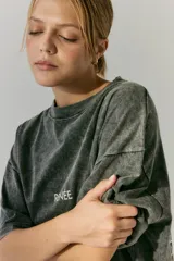 Remerón negro con efecto acid wash y estampa en serigrafía en frente y espalda con un ángel y texto en blanco.