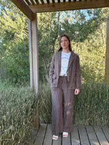 Blazer azul marino con rayas verticales blancas, confeccionado en lino italiano. Tiene botones de coco, solapas clásicas y bolsillos delanteros.