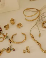 Par de aros dorados con forma cuadrada irregular y centro hueco.