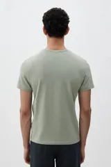 Remera verde oliva de algodón liviano, corte ajustado, cuello redondo ribeteado y bajo recto.