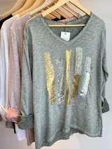 Remera manga larga color verde oliva, con escote en pico y estampa sublimada en el frente.