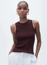 Musculosa blanca de tejido de punto fino, cuello redondo, tirantes anchos y diseño entallado.