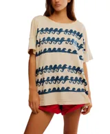 Remera color crema de manga corta holgada con estampado de olas azules.