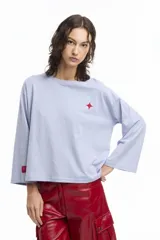 Remera blanca de manga larga con cuello redondo y pequeño logo estampado en el pecho y en la manga.
