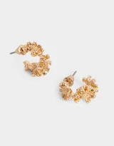 Aros tipo argolla bañados en oro con diseño de flores y cierre de tope a presión.