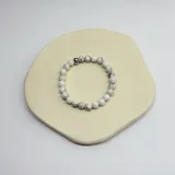 Pulsera elástica de cuentas redondas de howlita blanca con vetas grises.