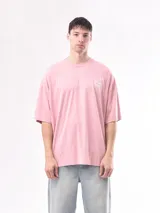 Remera rosa de corte holgado con cuello redondo y estampado pequeño en el pecho.