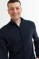 Campera gris oscuro de tejido de punto, con cuello alto, cierre frontal y bolsillos laterales.