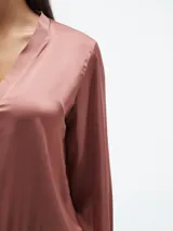 Blusa color cereza con escote en V y mangas largas abullonadas.