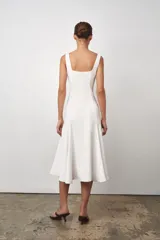 Vestido midi blanco de Zara Woman Collection, con escote cuadrado y sin mangas. Corte al cuerpo con falda evasé. Cierre con cremallera oculta en la costura.