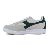 Championes casuales unisex Diadora modelo B.Elite ACBC, con capellada en tonos beige claro y gris claro, y detalles en verde oscuro en el logo lateral y talón. Suela blanca con motas de color reciclado.