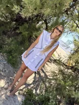 Vestido corto tipo camisa color beige con bordados florales en azul.