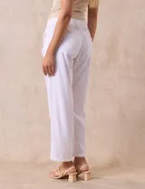 Pantalón largo de lino y rayón a rayas verticales grises y blancas. Tiene pretina elastizada con lazo de ajuste, bolsillos delanteros y traseros.
