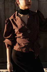 Camisa marrón con lunares blancos, corte clásico, cuello camisero, mangas 3/4 abullonadas y lazo ajustable en la cintura.