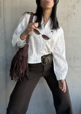 Camisa blanca con bordado floral, cuello mao y mangas largas abullonadas.