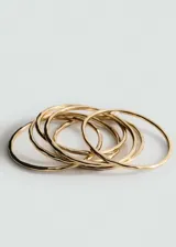 Set de seis pulseras rígidas doradas.