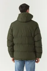 Campera puffer negra de nylon con cuello alto y capucha ajustable. Tiene bolsillos laterales y frontales con cierre.