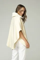 Poncho color crema con cuello de corderito desmontable y cierre dorado.