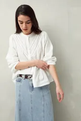 Camisa blanca de algodón con cuello mao, mangas abullonadas con puños abotonados y calados centrales.