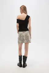 Minifalda de jean color beige con estampado animal print en tonos marrones.