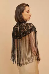 Capa corta negra con cuello alto y flecos largos. Diseño bordado con motivos florales y geométricos.