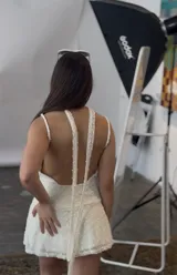 Vestido corto blanco con lunares en relieve, escote en V con detalle de encaje y breteles finos. Incluye choker haciendo juego.