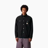 Chaqueta tipo camisa de color negro con cuello clásico y cierre frontal de botones metálicos. Presenta dos bolsillos de parche en el pecho con solapa y el logo de la marca Carhartt cosido en el bolsillo izquierdo.