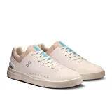 Championes urbanos de cuero sintético color blanco, con detalles en beige y celeste. Diseño minimalista con perforaciones laterales y logo de la marca en el lateral exterior.