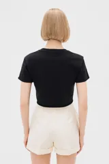 Remera cropped color rosa con estampado de conchas marinas en color rojo, corte holgado y cuello redondo.