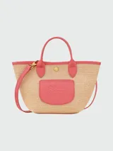 Bolso tipo tote de paja trenzada color beige con detalles en cuero verde. Tiene doble asa corta y correa larga extraíble.
