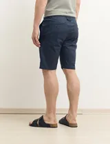 Bermuda de gabardina color verde con bolsillos laterales y traseros.