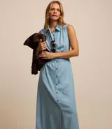 Vestido midi de jean celeste, sin mangas, con cuello camisero, abotonado al frente y con lastex en la cintura.