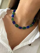 Collar corto tipo gargantilla compuesto por cuentas facetadas de vidrio o piedra en tonos azul lapislázuli y verde esmeralda, intercaladas con pequeñas cuentas espaciadoras plateadas.