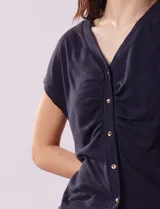 Remera blanca de lino, marca Zac & Rachel, con escote en V, abertura con botones y frunce en la parte delantera.