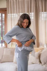 Pijama maternal gris con remera de manga larga con botones a los costados para amamantar y detalle de puntilla en el ruedo. Pantalón con calce maternal, elástico suave y lazo para ajustar la cintura.