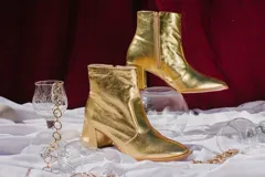 Botas plateadas de cuero con caña media, cierre lateral con cremallera y tacón geométrico.