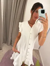 Vestido midi blanco con escote en V, abotonado al frente, mangas cortas con volados y falda evasé.