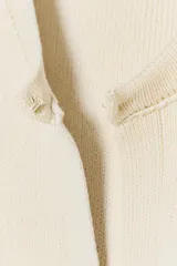 Chaqueta color crema de cuello redondo y manga larga, con bolsillos de parche con solapa en el frente y cierre frontal con corchete oculto.