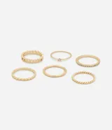 Set de seis anillos dorados de diferentes diseños: uno liso, uno con una piedra, uno con strass, uno retorcido, uno con textura de lunares y uno con textura de eslabones.