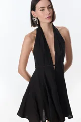 Vestido corto fucsia con escote halter y espalda descubierta.