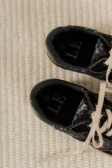 Championes acordonados color beige y dorado con suela marrón.