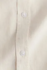 Camisa color crema de mezcla de lino y viscosa con cuello, botones adelante y canesú de doble capa con pliegue de caja en la espalda. Modelo de manga larga con bolsillo superior abierto, puños abotonados y bajo redondeado.