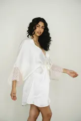 Bata corta color blanco de seda con mangas anchas terminadas en encaje. Incluye lazo de seda para ajustar en la cintura.
