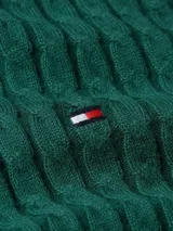 Sweater verde de punto trenzado de algodón orgánico, con cuello redondo y corte amplio. Presenta el logo de Tommy Hilfiger bordado en el pecho.