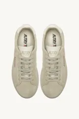 Championes Autry modelo Dallas Low, color beige confeccionados en gamuza con detalles en cuero blanco en el talón y logo de la marca en el lateral.