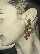 Aros colgantes con forma de serpiente de 6cm de alto, color dorado con glitter y cierre a presión de acero inoxidable.