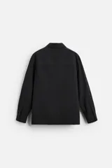 Camisa color crema de corte relaxed fit, confeccionada en tejido de mezcla de algodón suave al tacto. Tiene cuello solapa, manga larga con puños abotonados, un bolsillo de parche en el pecho y cierre frontal con botones.