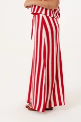 Falda larga tejida a rayas verticales rojas y blancas, con pretina elástica y tajos laterales.
