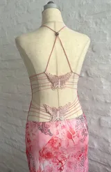 Vestido largo rosado con estampado abstracto en tonos rojos y grises, con breteles finos y espalda descubierta.
